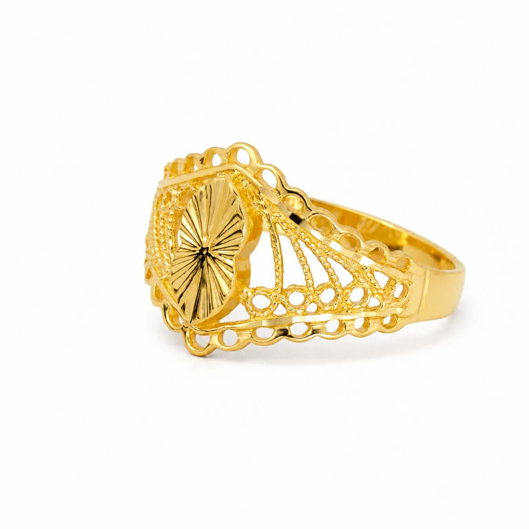 Anillo de oro amarillo estilo antiguo con filigrana calada y centro almendrado sobre fondo blanco.