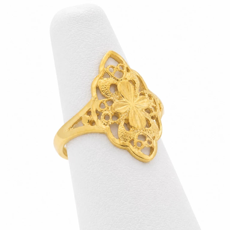Anillo antiguo de oro amarillo para mujer con diseño almendra, filigrana calada y flor central sobre exhibidor blanco.