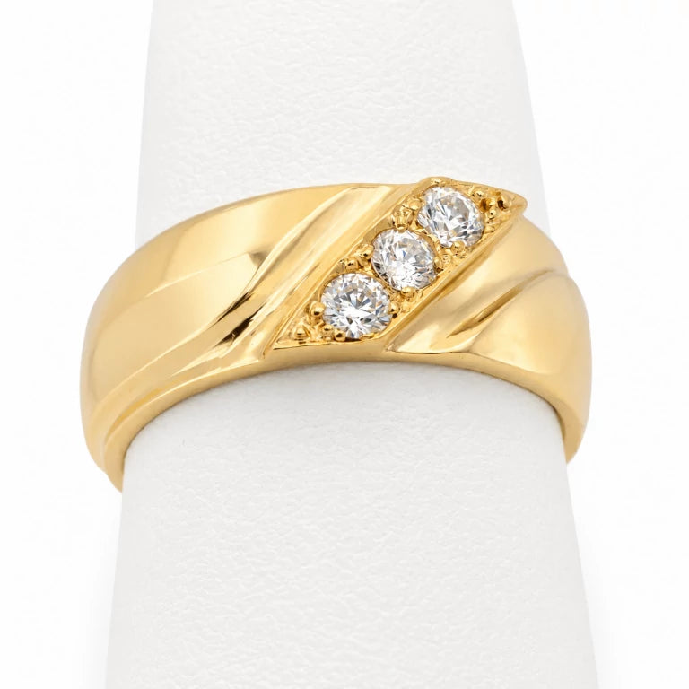 Anillo de boda para hombre en oro amarillo con tres piedras brillantes y diseño tipo banda elegante.