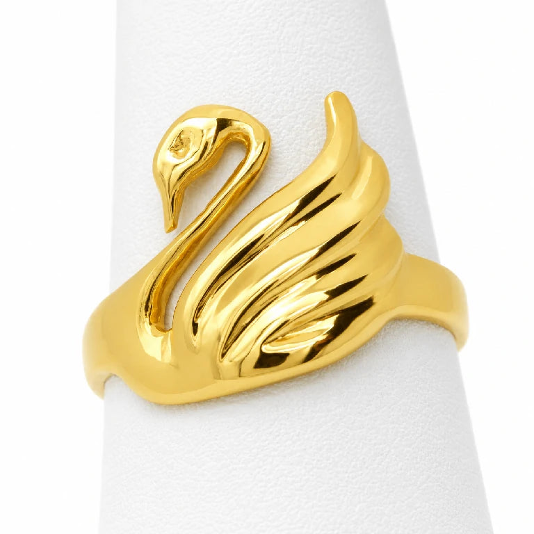 Anillo de oro amarillo con figura de cisne y alas en relieve visto sobre exhibidor blanco
