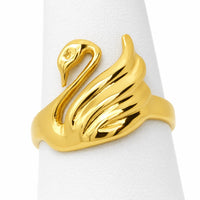Anillo de oro amarillo con figura de cisne y alas en relieve visto sobre exhibidor blanco