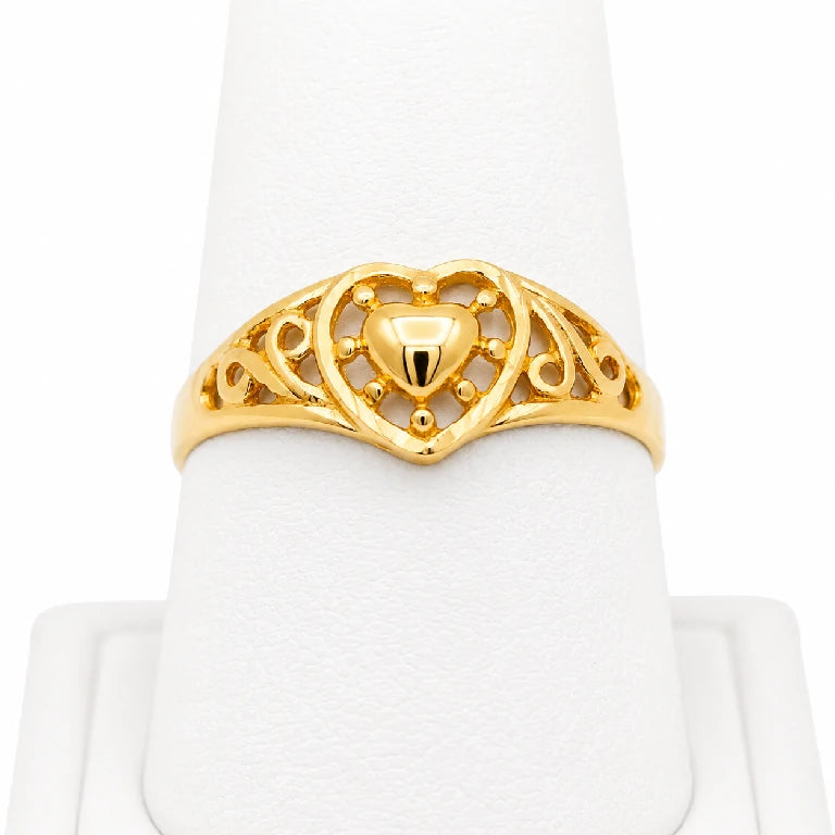 Anillo de oro amarillo 10k o 14k con corazón central y diseño calado para mujer, mostrado de frente en exhibidor blanco.