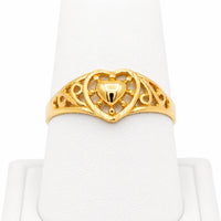 Anillo de oro amarillo 10k o 14k con corazón central y diseño calado para mujer, mostrado de frente en exhibidor blanco.