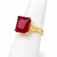 Anillo de corte esmeralda en oro amarillo con zirconia rectangular, montado en barras sólidas y acabado brillante.