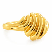 Detalle de los relieves curvos y el acabado pulido de un anillo domo de oro amarillo.