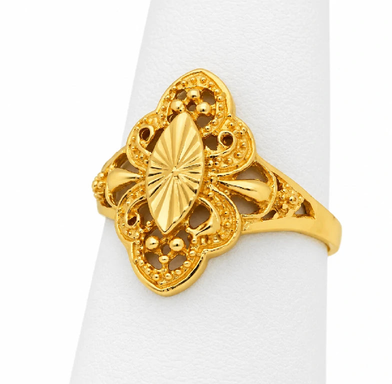Anillo de oro amarillo con centro de almendra y líneas radiales, rodeado de calado tipo filigrana sobre exhibidor blanco.