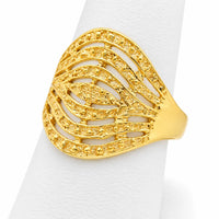 Anillo grande de oro amarillo sobre exhibidor blanco con diseño abierto y detalles decorativos brillantes.