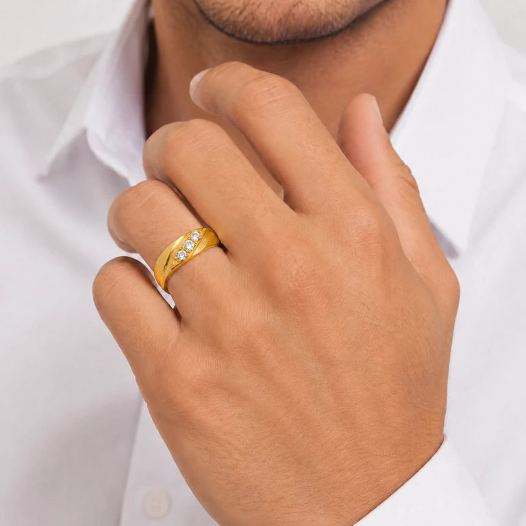 Joven con banda de oro para hombre y tres piedras brillantes en el dedo anular, con enfoque en el anillo.