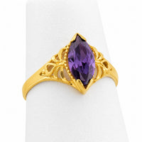 Anillo solitario marquesa de oro amarillo con piedra color amatista y elegantes detalles laterales calados.