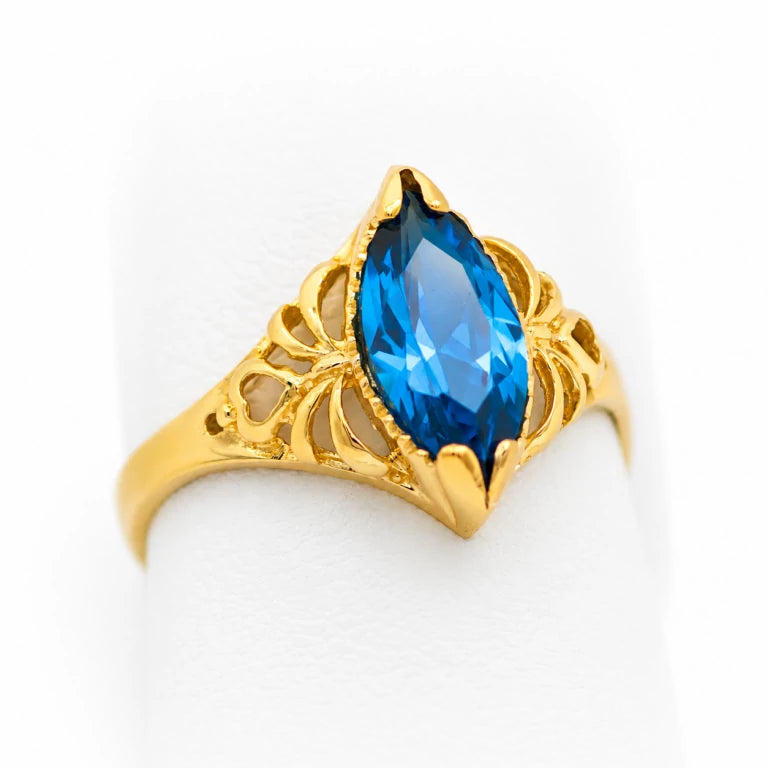 Anillo marquesa de oro amarillo para mujer con piedra azul espinela, acabado pulido y detalles calados.