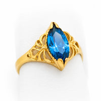 Anillo marquesa de oro amarillo para mujer con piedra azul espinela, acabado pulido y detalles calados.