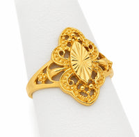 Anillo de oro con bolitas en los laterales y calado ornamental, visto en ángulo sobre exhibidor blanco.