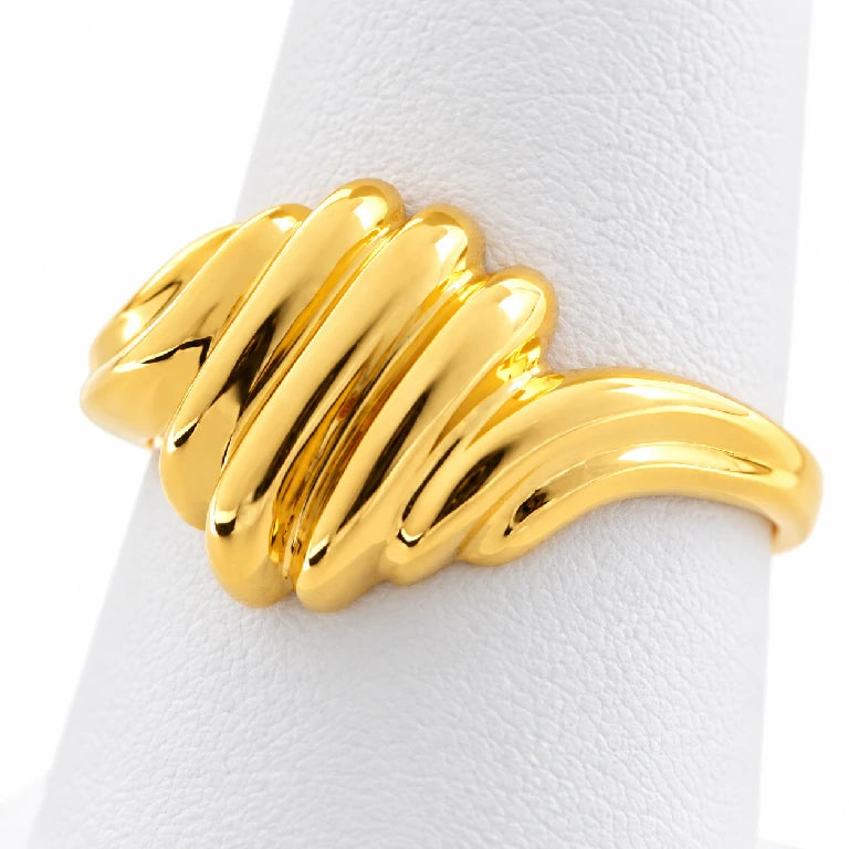 Anillo de oro amarillo estilo domo con relieves de concha, visto en diagonal sobre fondo blanco.