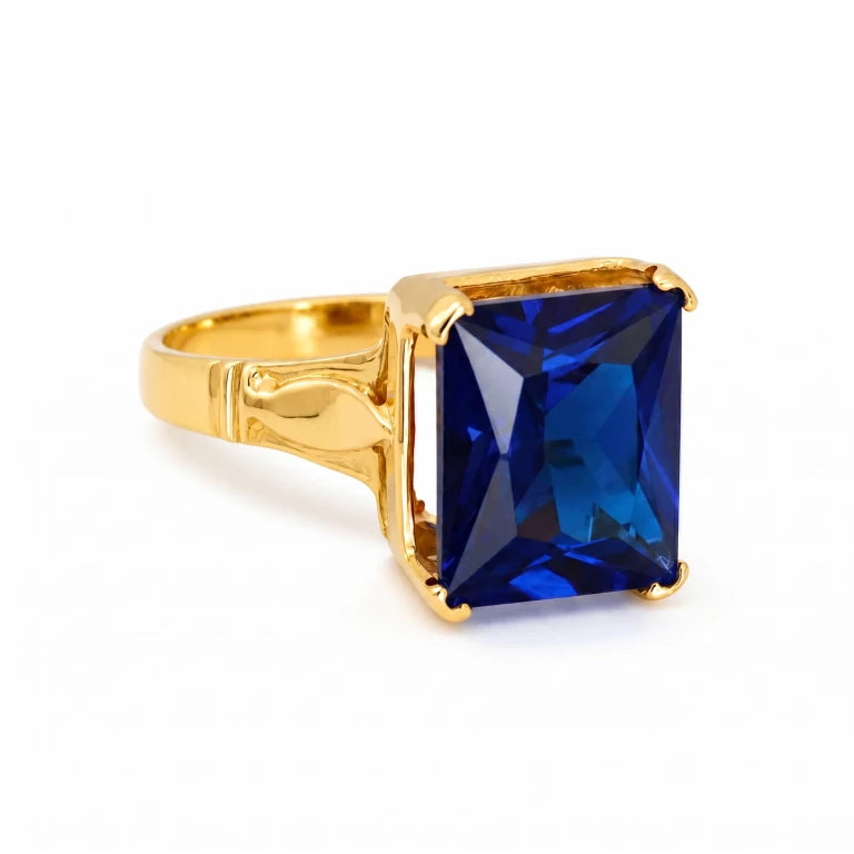 Anillo de corte esmeralda en oro amarillo con piedra azul zafiro rectangular, acabado pulido y estilo moderno para mujer.