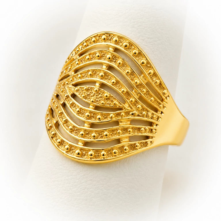 Detalle de anillo semanario calado en oro amarillo con bolitas decorativas, acabado satinado y diseño elegante para mujer