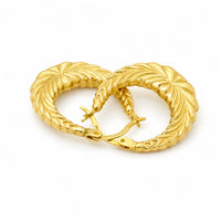 Par de argollas de oro estilo camarón con diseño de hojas en relieve y acabado brillante.