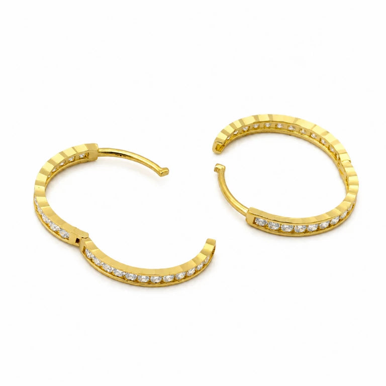 Aretes argollas de oro 10k para niñas mostrados abiertos, con textura facetada, fila de circonias blancas y práctico cierre articulado.