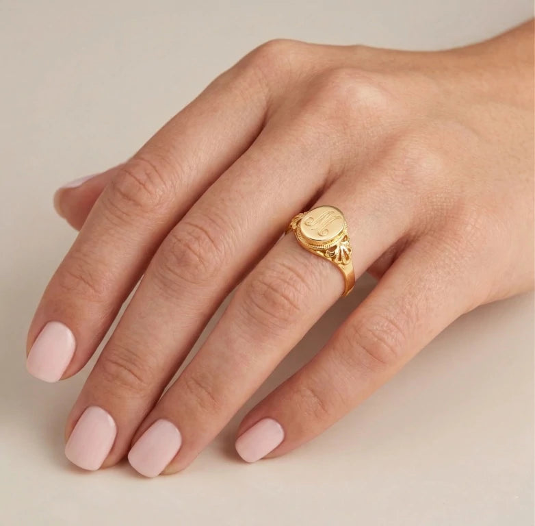 anillo de inicial gravada en el dedo de una cliente
